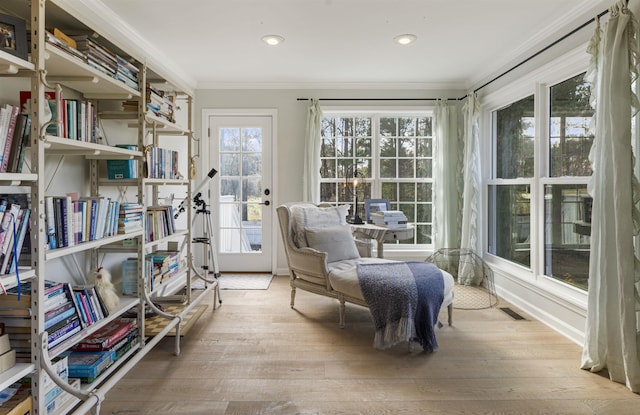 living area with ornamental molding, wood finished floors, visible vents, and recessed lighting