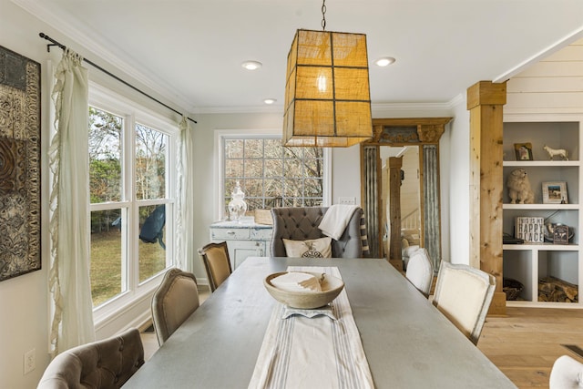 dining area with built in shelves, crown molding, decorative columns, recessed lighting, and wood finished floors