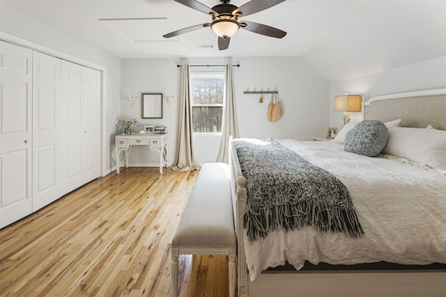 bedroom featuring light wood finished floors, visible vents, lofted ceiling, ceiling fan, and a closet