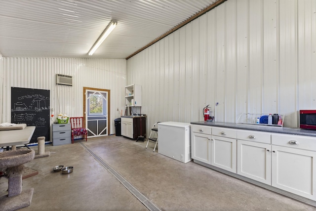 garage with a wall mounted AC, metal wall, and refrigerator