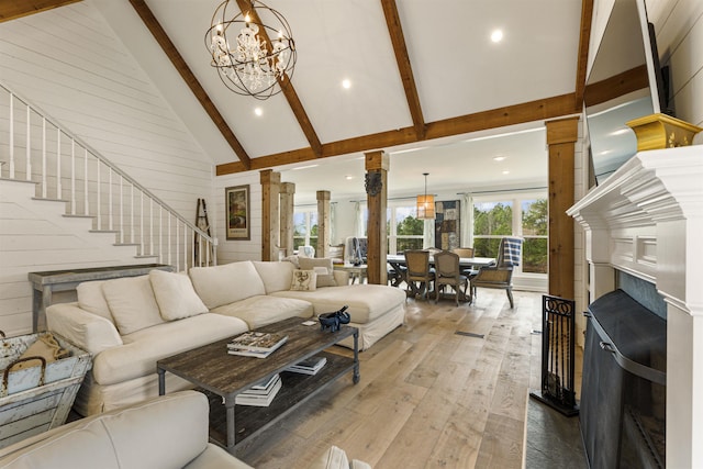 living room with high vaulted ceiling, hardwood / wood-style floors, beamed ceiling, decorative columns, and an inviting chandelier