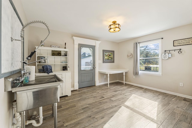 foyer featuring baseboards and wood finished floors