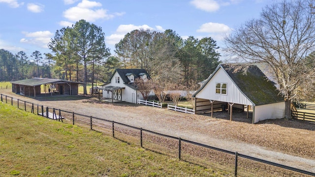 view of yard with dirt driveway, an outbuilding, and an exterior structure