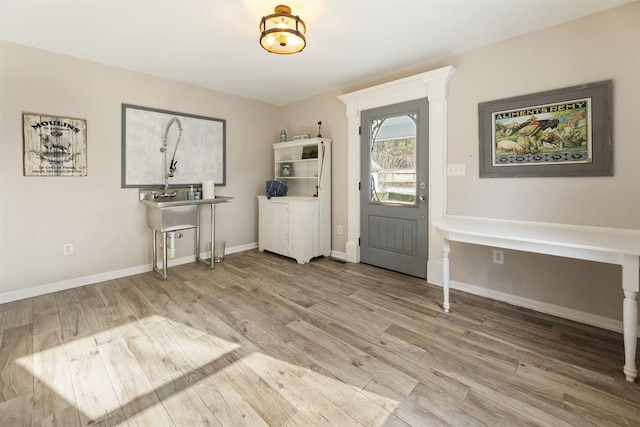 foyer with baseboards and wood finished floors