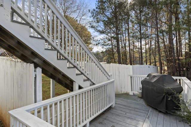 wooden deck featuring fence, stairway, and area for grilling