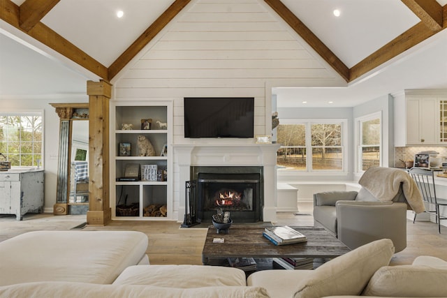 living room with high vaulted ceiling, a fireplace with flush hearth, beam ceiling, and light wood-style floors