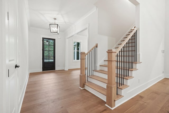 entryway featuring stairs, crown molding, wood finished floors, and baseboards