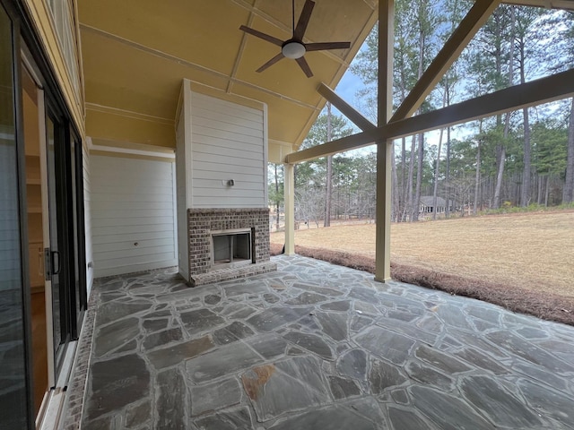 view of patio / terrace featuring ceiling fan and an outdoor brick fireplace