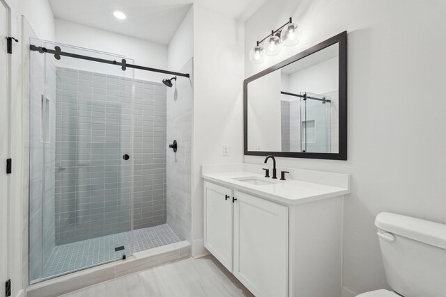 full bath featuring vanity, toilet, and a stall shower