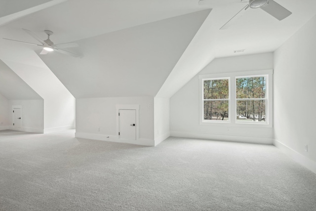 additional living space featuring visible vents, a ceiling fan, carpet flooring, baseboards, and vaulted ceiling