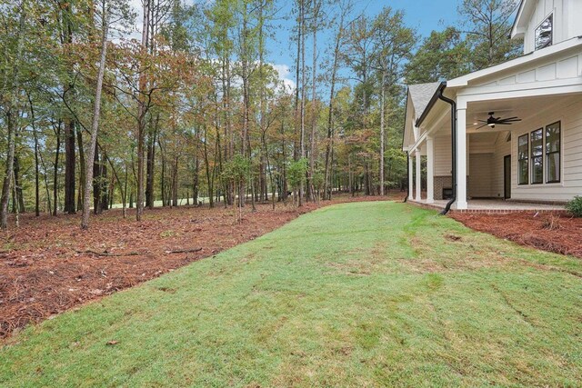 view of yard with ceiling fan and a patio area