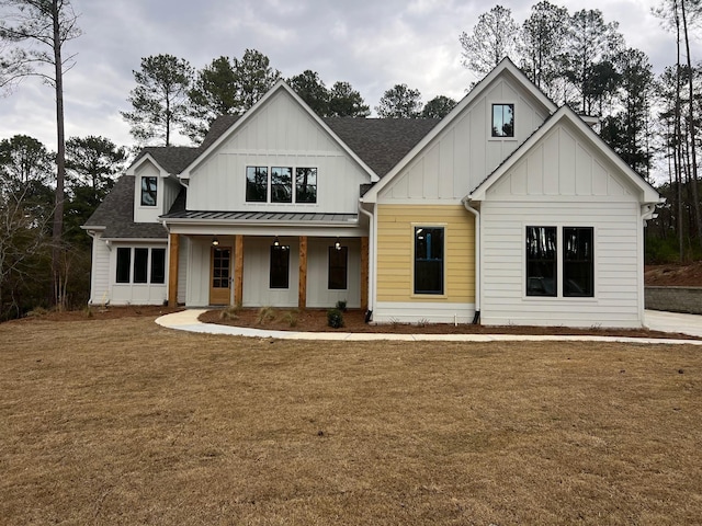 modern farmhouse style home featuring board and batten siding, a shingled roof, a front lawn, a porch, and a standing seam roof