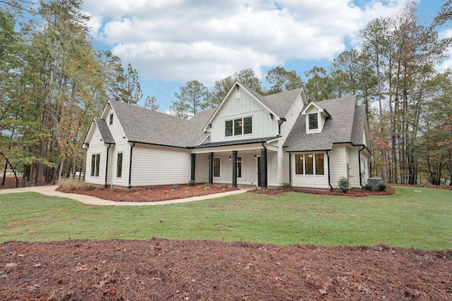 modern farmhouse style home with covered porch, board and batten siding, a shingled roof, and a front lawn