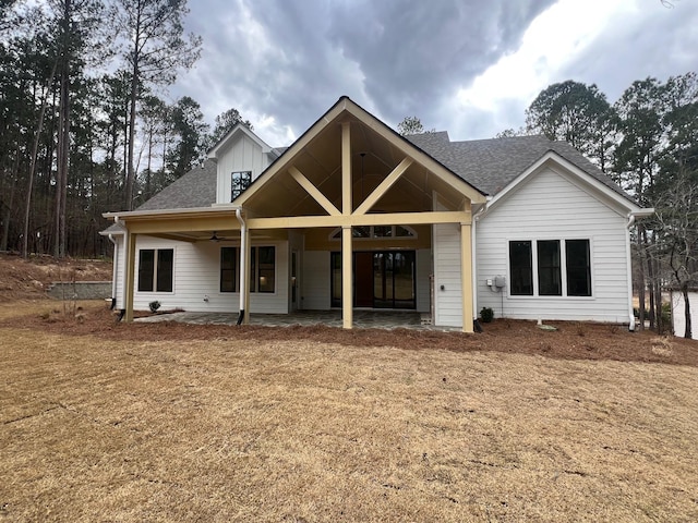 view of front facade featuring a patio area, ceiling fan, and roof with shingles