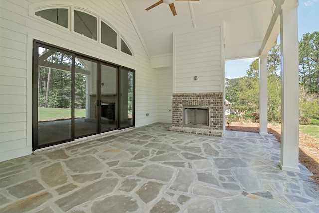 view of patio / terrace featuring a ceiling fan and a brick fireplace