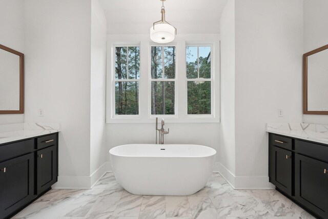 bathroom featuring baseboards, a soaking tub, marble finish floor, and vanity