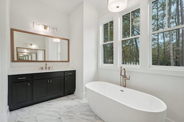 full bathroom featuring a freestanding bath, marble finish floor, and vanity