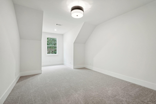 bonus room featuring baseboards, light carpet, lofted ceiling, and visible vents