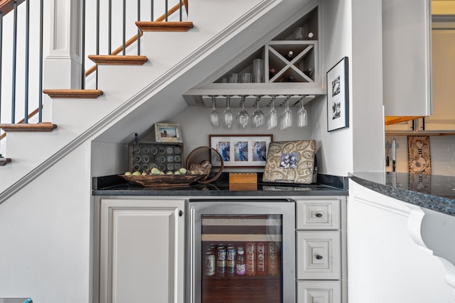 bar featuring tasteful backsplash, beverage cooler, and white cabinets