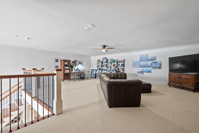 living room with ceiling fan, ornamental molding, and light carpet