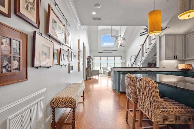 interior space with decorative light fixtures, sink, gray cabinetry, hardwood / wood-style flooring, and a high ceiling