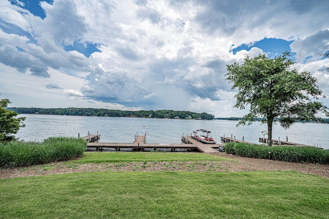 dock area with a water view and a yard