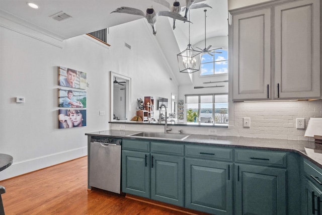 kitchen featuring hardwood / wood-style floors, sink, decorative backsplash, stainless steel dishwasher, and a notable chandelier