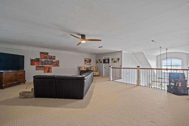 living room with ornamental molding, light colored carpet, and ceiling fan