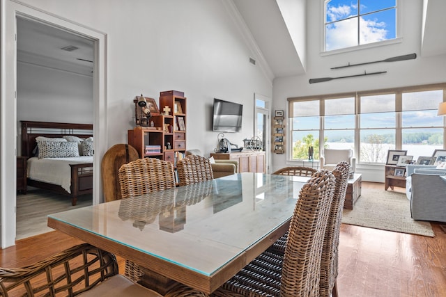 dining area with hardwood / wood-style flooring and high vaulted ceiling