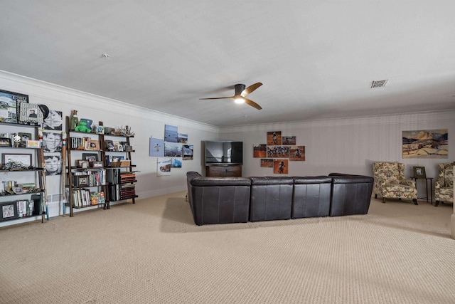 living room with light carpet, ornamental molding, and ceiling fan