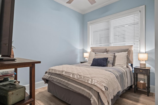 bedroom featuring hardwood / wood-style flooring, crown molding, and ceiling fan