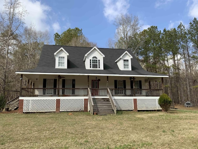 farmhouse inspired home with a front yard, ceiling fan, and covered porch