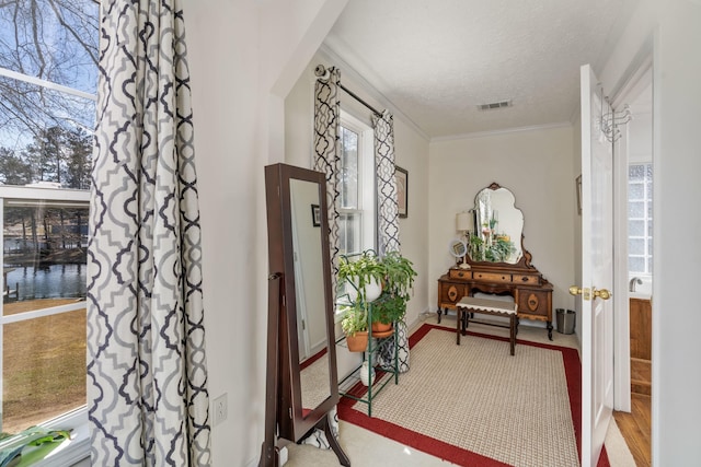 foyer entrance with crown molding and a textured ceiling