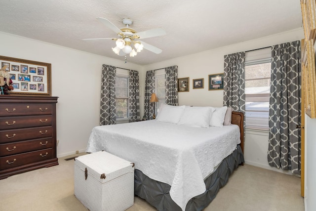 bedroom featuring ceiling fan, light carpet, and a textured ceiling