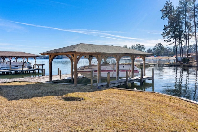 view of dock with a water view and a lawn