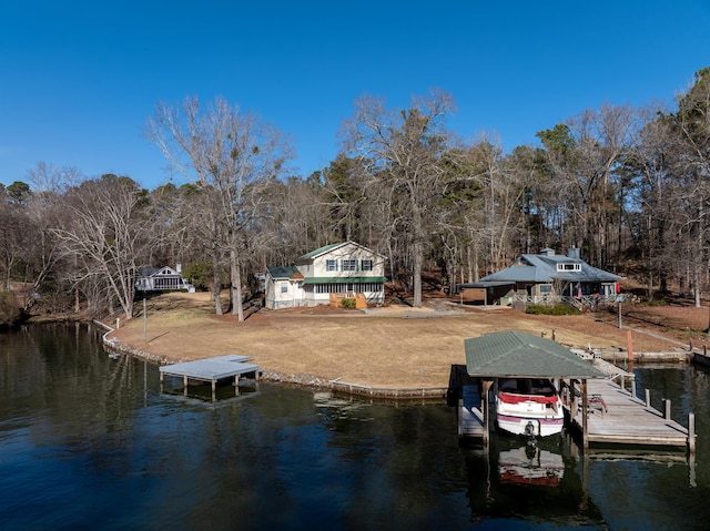 view of dock with a water view and a yard