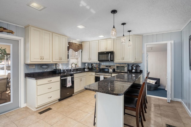 kitchen with sink, a breakfast bar area, dark stone countertops, pendant lighting, and black appliances