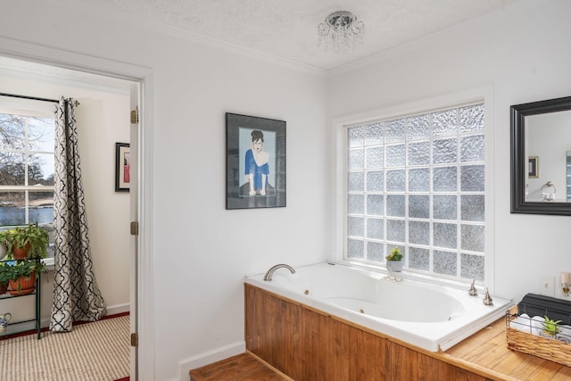 bathroom with crown molding, a tub to relax in, and a textured ceiling