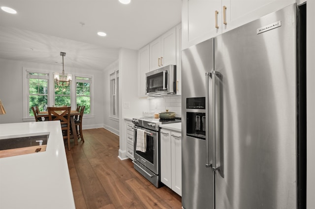 kitchen with tasteful backsplash, decorative light fixtures, dark hardwood / wood-style floors, stainless steel appliances, and white cabinets