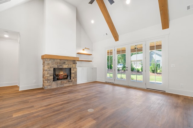 unfurnished living room featuring ceiling fan, wood-type flooring, high vaulted ceiling, and beamed ceiling