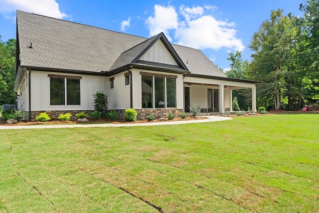 back of property featuring central AC unit and a yard