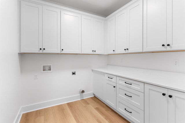 2050 Osprey Poynte, Greensboro, GA 30642 - laundry area featuring cabinet space, hookup for a washing machine, hookup for an electric dryer, and light wood-style floors