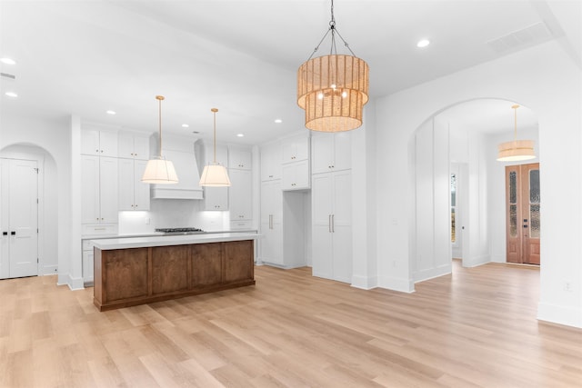 2050 Osprey Poynte, Greensboro, GA 30642 - kitchen with arched walkways, custom range hood, light wood-type flooring, and recessed lighting