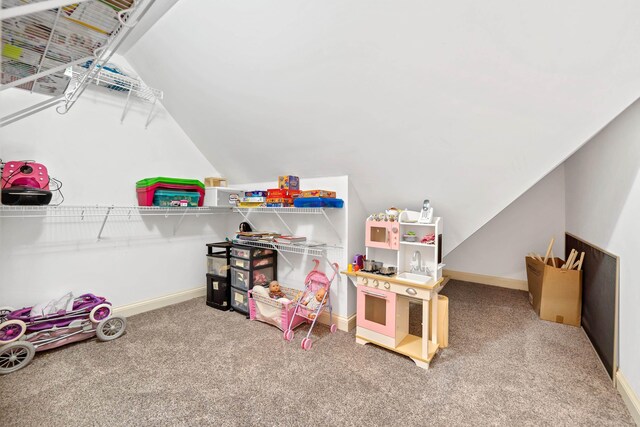 playroom with lofted ceiling, carpet, and baseboards