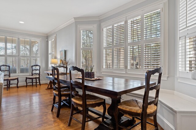 dining area with a wealth of natural light, baseboards, wood finished floors, and ornamental molding