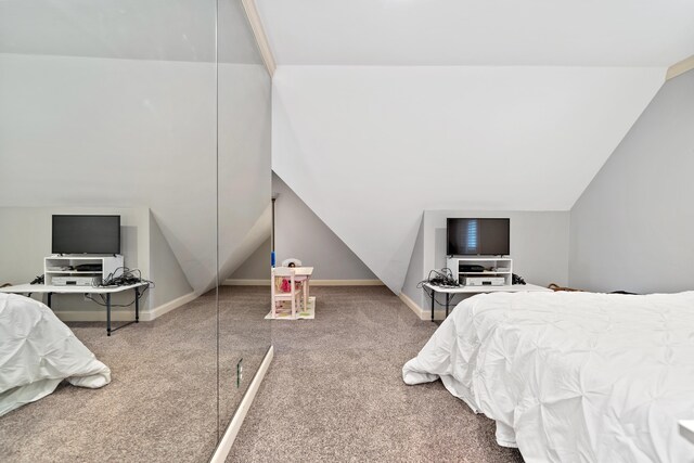 carpeted bedroom featuring baseboards and lofted ceiling