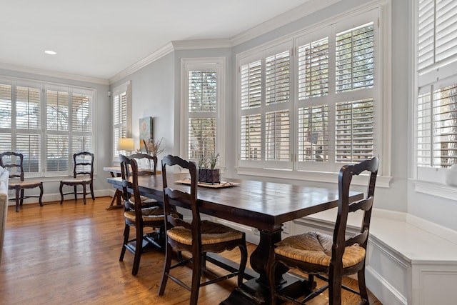 dining room with plenty of natural light, wood finished floors, and crown molding