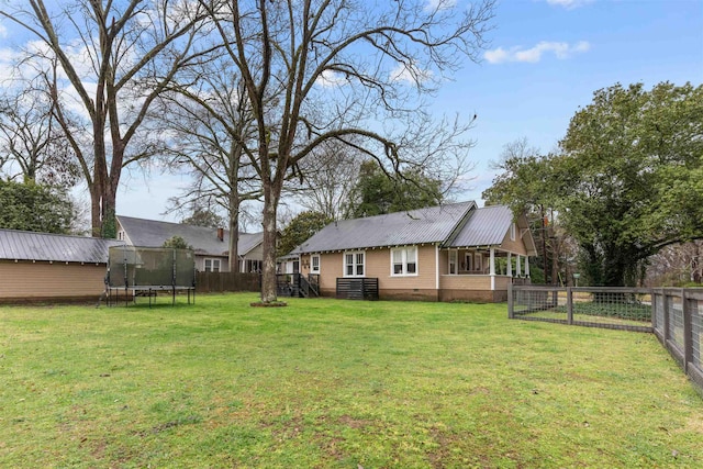 view of yard featuring a trampoline and a fenced backyard