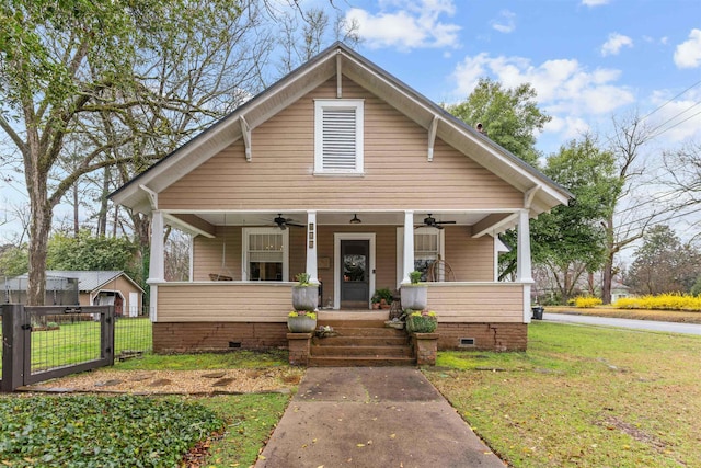 bungalow-style house with a ceiling fan, fence, covered porch, a front yard, and crawl space