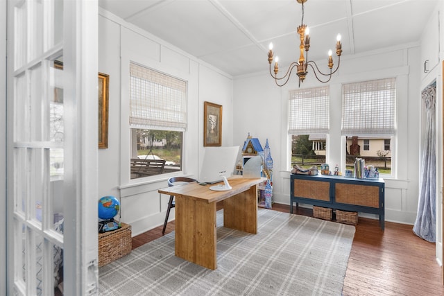 office featuring a notable chandelier, light wood-style flooring, and a decorative wall